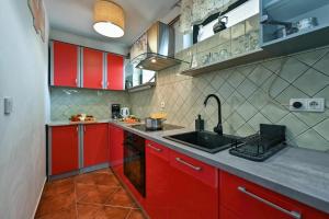 a kitchen with red cabinets and a sink at Twin Oasis Retreat with Pool & Spa - Happy Rentals in Biškupec Zelinski