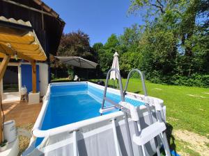 a white swimming pool with an umbrella next to a yard at B&B immersif La Chambre de Ratatouille 10 min Disney in Isles-lès-Villenoy
