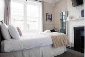 a white bedroom with a bed with a fireplace at Ship Inn in Wylam
