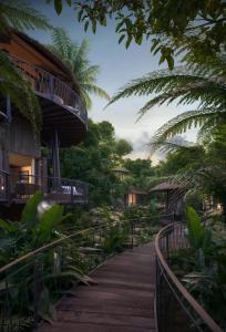 a walkway in front of a resort with trees at Twinpalms Treehouses Phuket in Bang Tao Beach