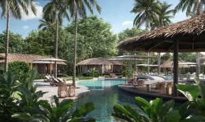 a pool at a resort with chairs and umbrellas at Twinpalms Treehouses Phuket in Bang Tao Beach