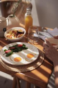 a table with a plate of eggs and a bowl of food at Sea Lily Suites Milos in Paleochori