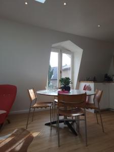 a dining room with a table and chairs and a window at Logement Welgelegen - Charming private stay with sauna near Nijmegen in Millingen aan de Rijn +19 photos