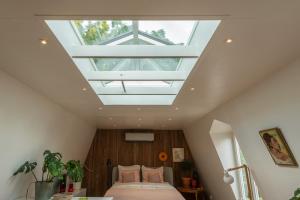 a bedroom with a bed under a skylight at Logement Welgelegen - Charming private stay with sauna near Nijmegen in Millingen aan de Rijn