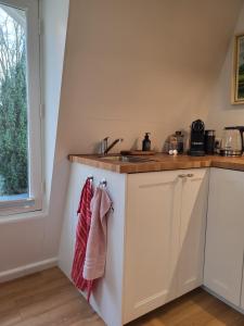 a kitchen with white cabinets and a sink at Logement Welgelegen - Charming private stay with sauna near Nijmegen in Millingen aan de Rijn
