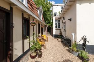 a courtyard with chairs and plants on a building at Logement Welgelegen - Charming private stay with sauna near Nijmegen in Millingen aan de Rijn