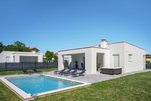 a white house with a swimming pool in the yard at Villa Vallis in Nedeščina