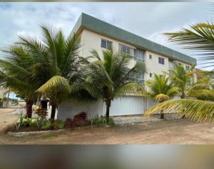 a house with palm trees in front of it at Apartamento Castelhanos ES in Anchieta