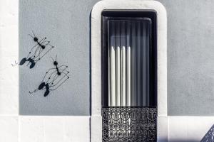 a window with three ants on the side of a building at RM The Experience - Small Portuguese Hotels in Setúbal