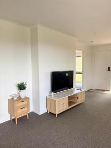 a living room with a flat screen tv on a wall at Valley View House in Gympie