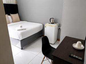 a small room with a bed and a chair and a table at Springforth Guesthouse in De Grendel