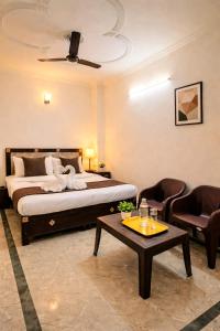 a bedroom with a bed and a table and chairs at Wama Rooms in New Delhi +3 photos