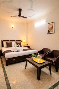 a bedroom with a bed and a table and chairs at Wama Rooms in New Delhi