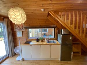a kitchen with a refrigerator and a sink in a cabin at 서귀포 다붓 in Susal-li