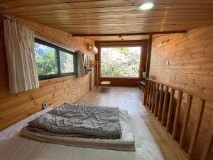 a large bed in a wooden room with a window at 서귀포 다붓 in Susal-li