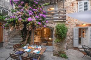 a table with plates of food and flowers on it at Charming Stone House with Green Courtyard in Stari Grad