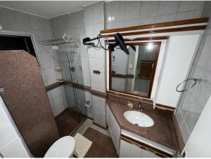 a bathroom with a sink and a mirror and a toilet at Apartamento Castelhanos ES in Anchieta +7 photos