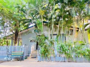 a house with palm trees and a bench in front of it at Amrapali Villa at Raghunandan Resort in Nashik
