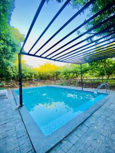 a pergola over a swimming pool in a backyard at Amrapali Villa at Raghunandan Resort in Nashik +15 photos