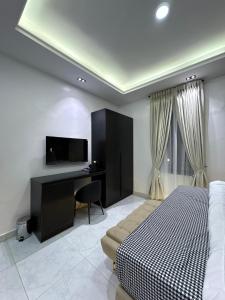 a bedroom with a bed and a desk with a television at JKB PREMIUM lUXURY in Lekki