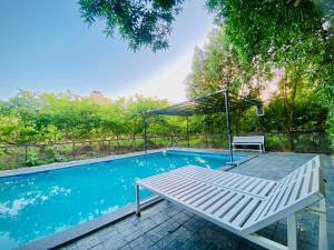 a swimming pool with a bench next to a bench at Amrapali Villa at Raghunandan Resort in Nashik