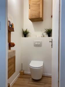 a bathroom with a toilet and plants on the wall at L'Écrin in Béziers