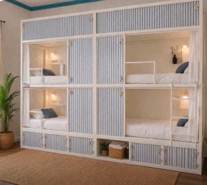 a large white room with bunk beds in it at Ria Surf & Stay in Faro +15 photos