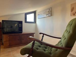 a living room with a chair and a tv at La Loggetta in Bagnaia