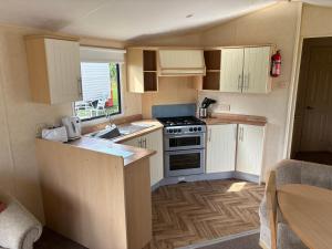 a small kitchen with a stove and a sink at 19 Vale Park in Fishguard
