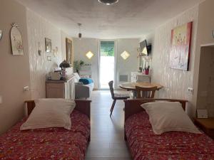 a bedroom with two beds and a table and a dining room at Le temps d'une pause bed and breakfast in Servance