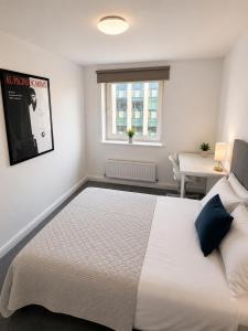 a bedroom with a large white bed and a desk at Modern Bright Flat Central & Stylish in Central Station