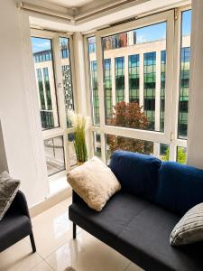 a living room with a blue couch in front of a window at Modern Bright Flat Central & Stylish in Central Station