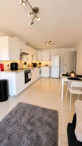 a kitchen with white cabinets and a table and chairs at Modern Bright Flat Central & Stylish in Central Station +3 photos