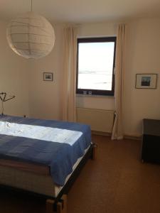 ein Schlafzimmer mit einem Bett und einem großen Fenster in der Unterkunft Leinetalblick in Volkerode