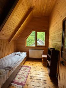 ein Schlafzimmer mit einem Bett in einem Holzhaus in der Unterkunft Hostel & Camping Rilindja in Valbonë