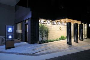 um edifício com uma placa à frente à noite em アスティルホテル新大阪 プレシャス em Osaka