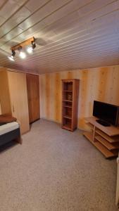 an empty room with a bed and a desk and a television at Ferienwohnung Altrichter 1 in Wabern