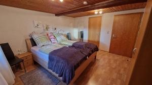 a bedroom with a bed and a wooden floor at Ferienwohnung Altrichter 1 in Wabern