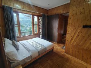 a bedroom with a bed and a large window at Bhaderwah Resorts Pvt Ltd in Dranga +25 photos