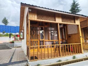 a small building with wooden doors and a fence at Bhaderwah Resorts Pvt Ltd in Dranga