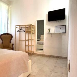 ein Schlafzimmer mit einem Fernseher an der Wand und einem Spiegel in der Unterkunft Podere 406 in Pescia Romana