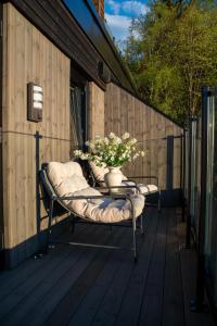 a bench with a vase of flowers on a deck at Modern apartment with balcony and view in Trondheim