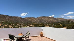 a balcony with two chairs and a table with a view of mountains at Peaceful Retreat in Oulad Akkou