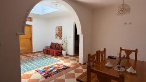 a living room with a table and a red couch at Peaceful Retreat in Oulad Akkou