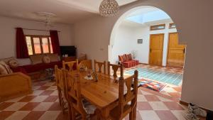 a dining room with a table and a living room at Peaceful Retreat in Oulad Akkou