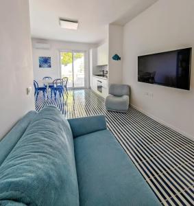 a living room with a blue couch and a flat screen tv at Minnelea Blue Retreat in Acciaroli