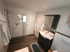 a bathroom with a sink and a shower at Haus am Deich in Norden