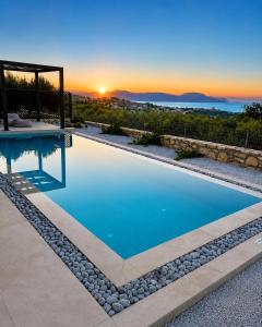 a swimming pool with a sunset in the background at Casa Ydor in Koúfi