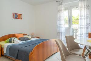 a bedroom with a bed and a table and chairs at Apartmani Aleks in Budva