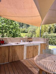 an outdoor kitchen under an umbrella on a deck at Bastide Sainte Trinide in Sanary-sur-Mer